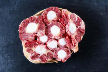 Fresh Raw Beef Oxtail Meat cut, ready to cook. on Blue stone  Background.