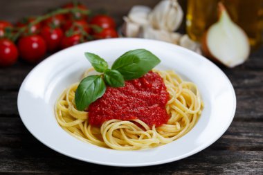 Spaghetti with marinara sauce and basil leaves on top, decorated
