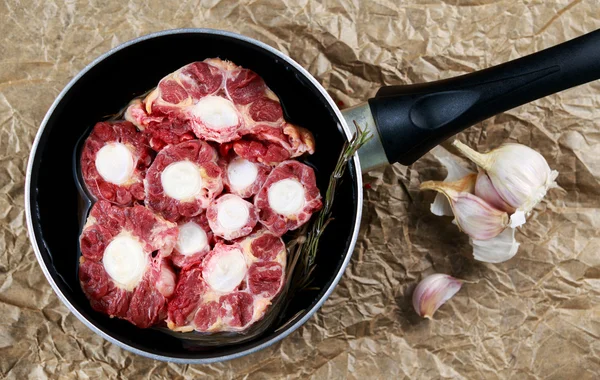 पॅनमध्ये ताजे कच्चे बीफ ऑक्सटेल मांस कट, स्वयंपाक करण्यास तयार. भाज्यांसह. ब्लू दगड पार्श्वभूमीवर . — स्टॉक फोटो, इमेज