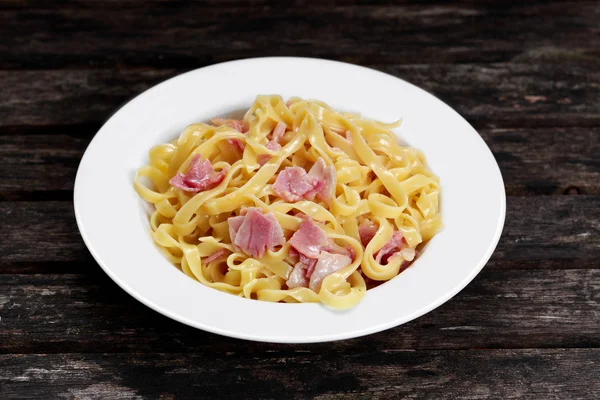 Pasta carbonara con espaguetis tagliatelle con tocino, york de huevo y queso parmesano . — Foto de Stock