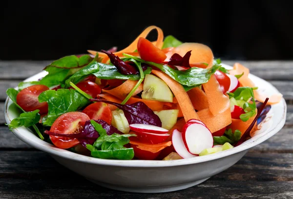 Eski ahşap masa üzerinde taze sebze salatası. — Stok fotoğraf