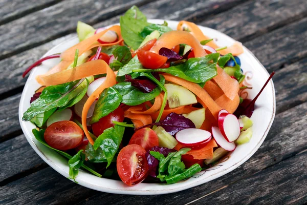 Eski ahşap masa üzerinde taze sebze salatası. — Stok fotoğraf