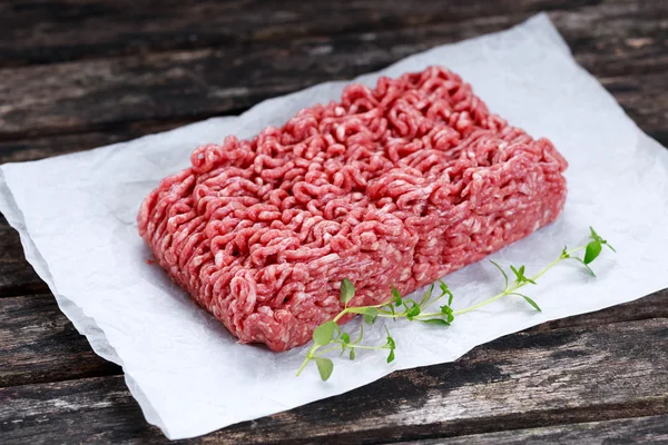 Verse rauwe gehakt rundvlees op verfrommeld papier — Stockfoto