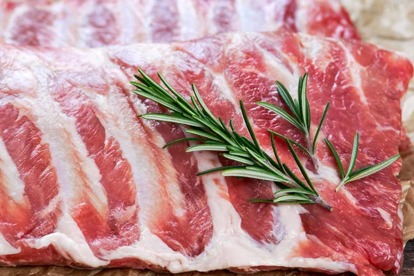 Costillas de cerdo crudas con un romero. sobre papel arrugado — Foto de Stock