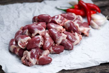 Buruşuk kağıt, ham ördek kalpler sebze ile dekore edilmiştir. eski ahşap tablo.