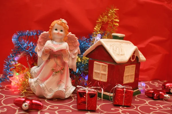 Pequeña casa de juguete y estatuilla de ángel — Foto de Stock
