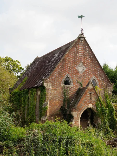 Igreja velha ou capela semi-crescida com um weathervane — Fotografia de Stock