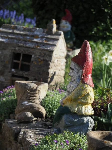 Un gnomo de jardín de piedra en primer plano en un hermoso jardín —  Fotos de Stock