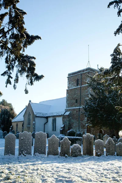 Uma igreja velha e fileira de lápides na neve — Fotografia de Stock