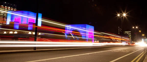 Panoramic crop of light trails across a bridge at night — Stock Photo, Image