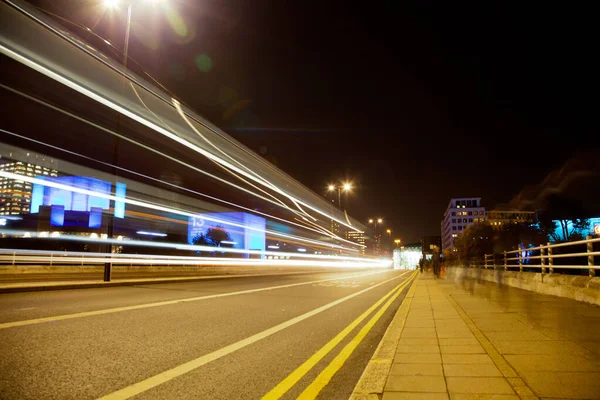 长期曝光的图片，人们和车辆在夜晚穿过一座桥 — 图库照片