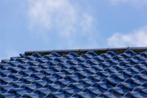 Close-up tiro de um telhado de azulejo azul envidraçado com um céu azul no fundo — Fotografia de Stock