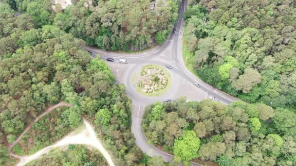 Légi felvétel egy közúti körforgalomról Dorset erdős és pogány területén, forgalomáramlással — Stock videók