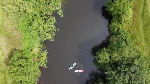 Una vista aerea da direttamente sopra di due pedane che lentamente girano su un fiume — Video Stock