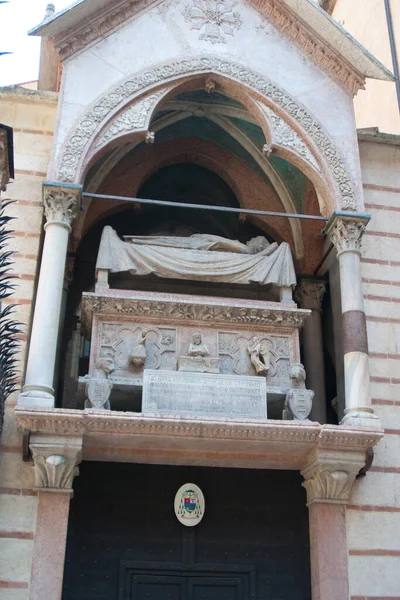 O memorial de pedra ornamentada e túmulo sob um arco em um edifício em uma cidade toscana — Fotografia de Stock