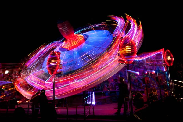 Long exposure picture of a fairground ride at night — Stock Photo, Image