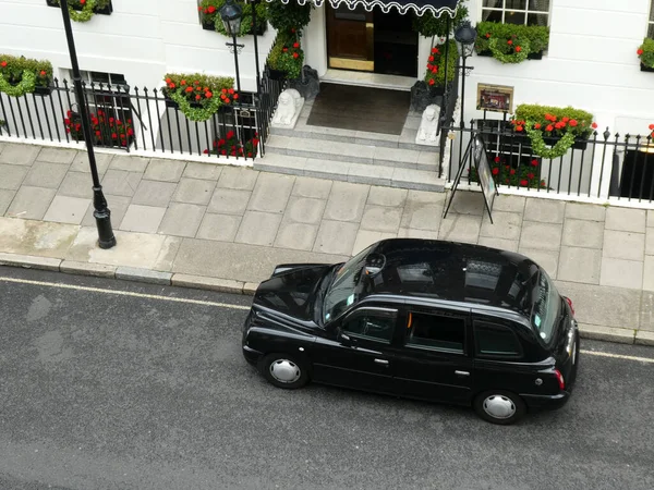 En svart taxi sett väntar utanför ett hotell i London — Stockfoto