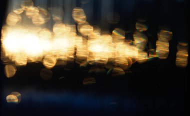 Koyu mavi ve gri bir arkaplan karşısında kasten bulanık altın renkler.