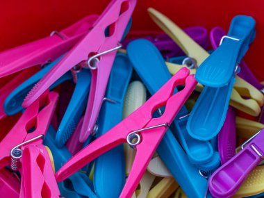 Mavi pembe hareket ve sarı plastik yıkama mandalları yakından görülüyor.