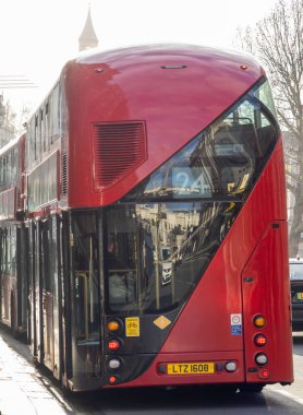 İki modern kırmızı çift katlı Londra otobüsü bir caddede park halinde görüldü.