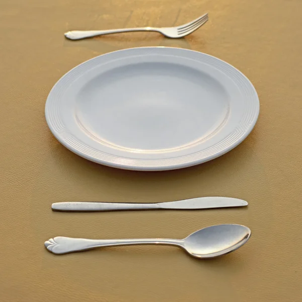 Κουτάλι πιρούνι μαχαίρι και άδειο άσπρο πιάτο — Φωτογραφία Αρχείου