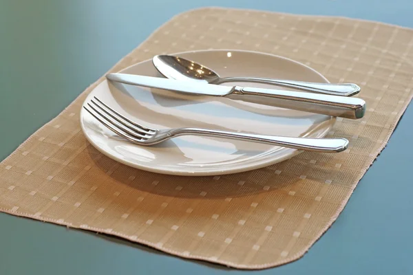 Spoon fork and knife on empty white plate — Stock Photo, Image