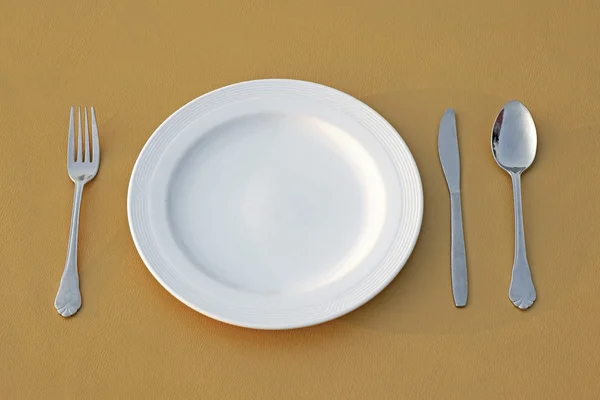 Нож для ложки и пустая белая тарелка — стоковое фото