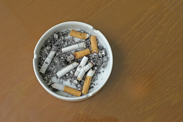 Cigarros fumados em cinzeiro branco — Fotografia de Stock