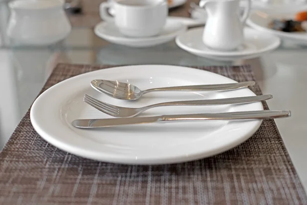 Spoon fork and knife on white plate — Stock Photo, Image