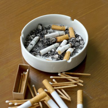 Beyaz kül tablası ve kibrit çöpü içinde sigara füme 
