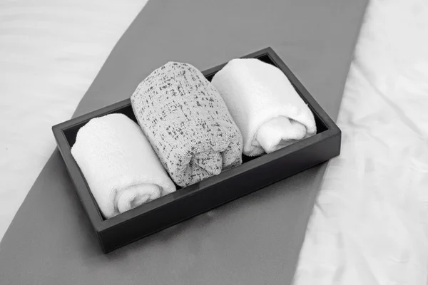 Handtücher in schwarzem Tablett auf dem Bett — Stockfoto