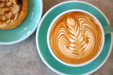 Tahta masada bir fincan sıcak latte sanat kahvesi.