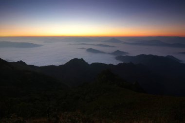 Dağ tepelerinde sisli güzel gökyüzü arkaplanlı
