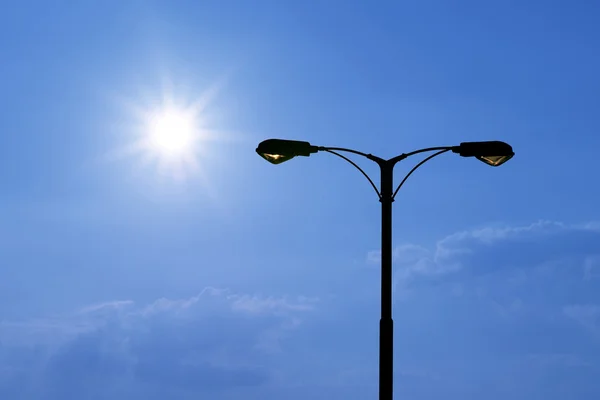 Sziluettjét a gyönyörű napfény streetlight — Stock Fotó