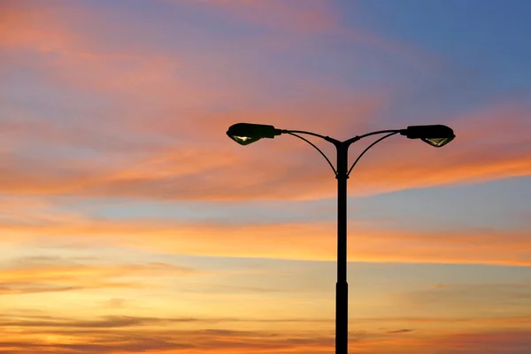 Sziluettjét a gyönyörű twilight streetlight — Stock Fotó