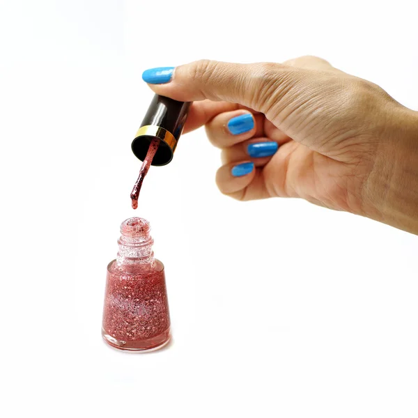 Vrouwelijke hand dropping nagellak in nagellak fles isoleren — Stockfoto