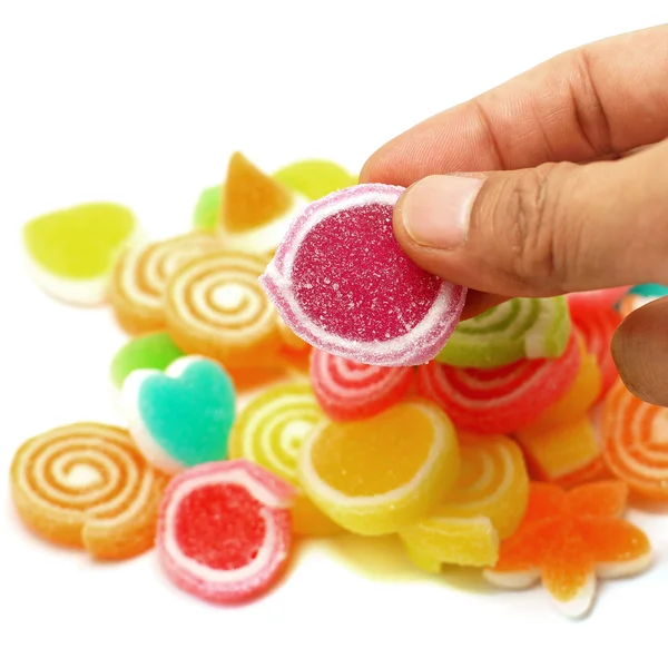 Human hand pick up jelly sweet candy — Stock Photo, Image