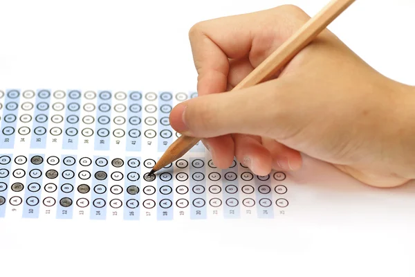 Hoja de respuesta puntuación de prueba con lápiz y mano humana —  Fotos de Stock