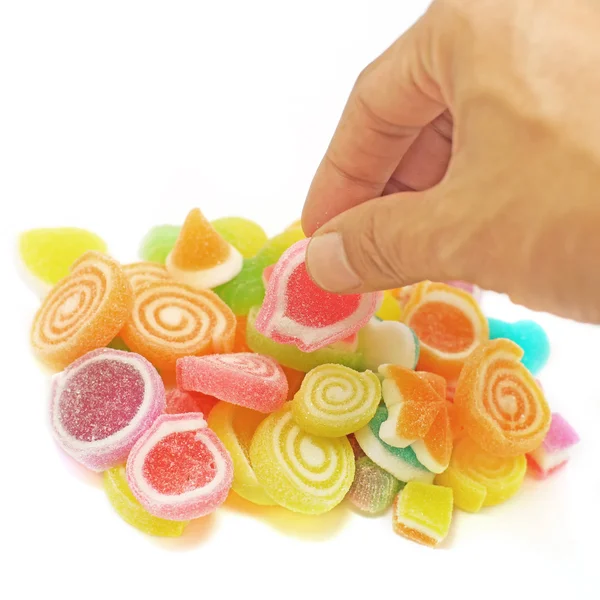 Mano umana raccogliere caramelle gelatina dolce isolato su bianco — Foto Stock