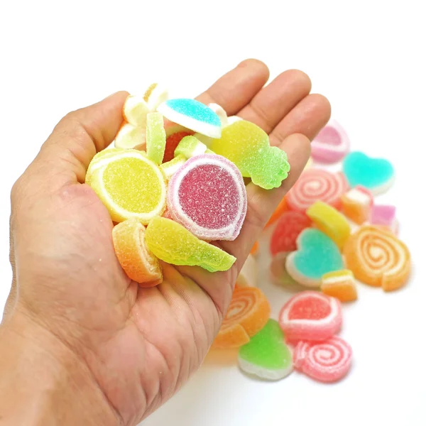 Human hand pick up jelly sweet candy isolated on white — Stock Photo, Image