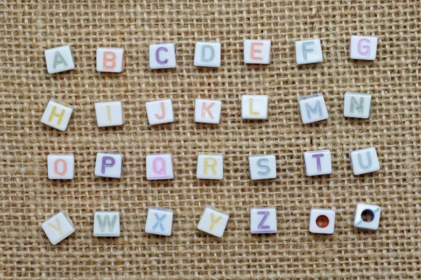 A-z english alphabet on burlap background — Stock Photo, Image