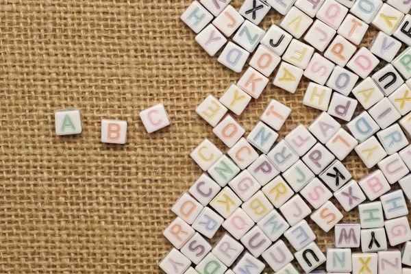 Abc english alphabet on burlap background — Stock Photo, Image