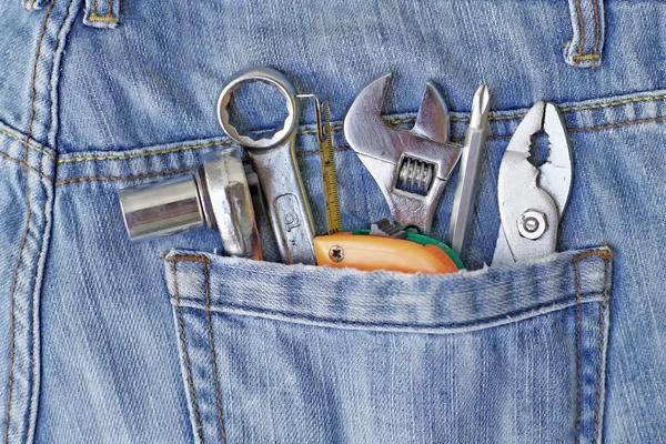 Mehrere Werkzeuge in Arbeiterjeans — Stockfoto