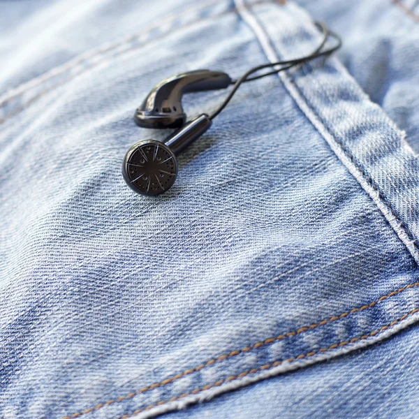 Black earbuds in back pocket jeans — Stock Photo, Image