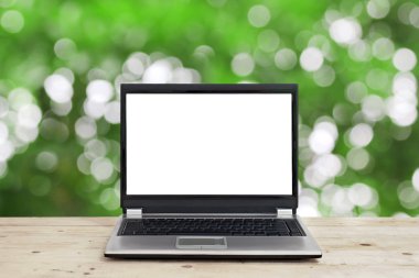 bokeh arka plan ile ahşap masa boş ekran ile dizüstü bilgisayar