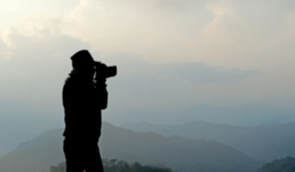 Blurry silhouette photographer is taking photos — Stock Photo, Image