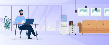 Genç yakışıklı iş adamı ofis iç tasarımında masada oturuyor.