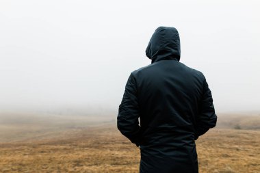 Genç adam dağlarda yağmurlu bir kış sabahı doğayı keşfediyor.