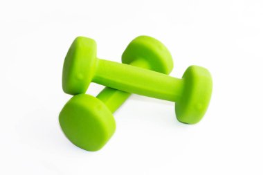 Beyaz arkaplanda iki açık yeşil dambıl var. Spor malzemeleri.