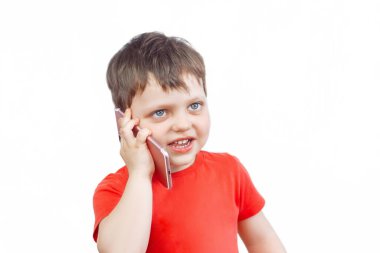 Kırmızı tişörtlü bir çocuk telefonda konuşuyordu. İzole edilmiş beyaz bir geçmişi olan küçük bir çocuk.